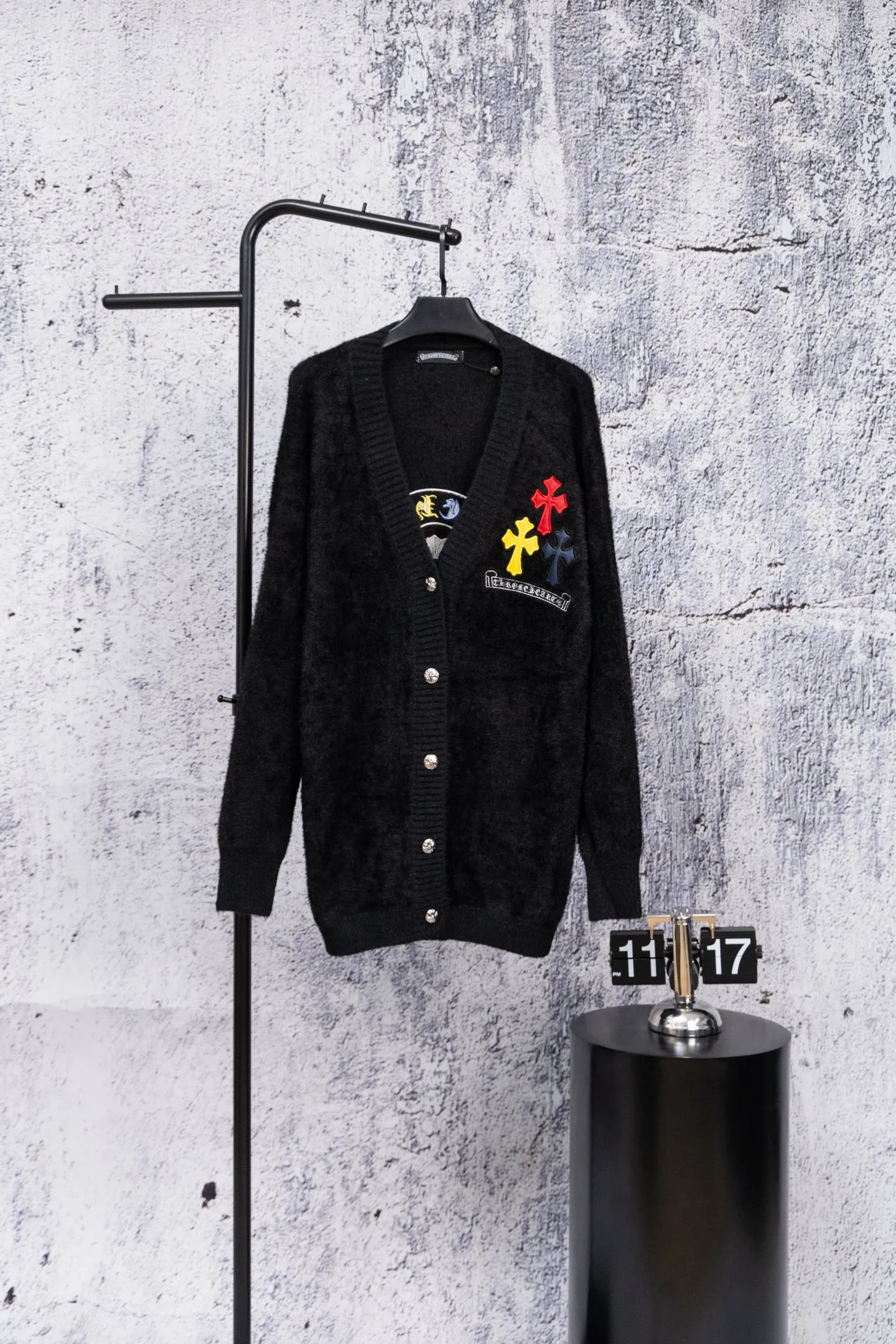 P300 Chrome Hearts CH Chrome Hearts 2026 new cross loose knitted V-neck cardigan Fabric: Made of plush textured knitted material, soft to the touch and with a lazy atmosphere; Decoration: Red, yellow, and black cross ornaments on the chest, paired with brand logo patches, which are iconic elements of street fashion brands (such as Chrome Hearts style), enhancing visual recognition; Version: Loose version + single-row metal button design, combining casual feeling and practicality. 2. Style and Adaptation Style: It combines dark street style and gentle knitted texture, which belongs to the tone of "sweet and cool mix"; Scenario: Can be worn with a T-shirt/suspender to create a daily street look, or can be layered with a shirt for light casual wear. Color: Black White Size: M L XL